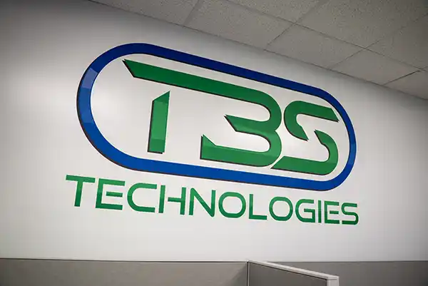 Photo of the TBS Technologies logo emblazoned on a wall